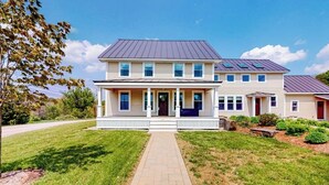 A two-story house with a front porch, a driveway, and a well-maintained lawn.