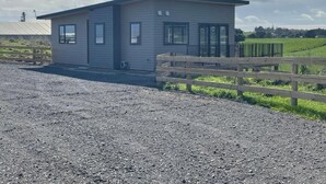 Un bâtiment d’un seul étage, doté d’un toit plat, de grandes fenêtres et d’une zone délimitée par une clôture à l’avant.