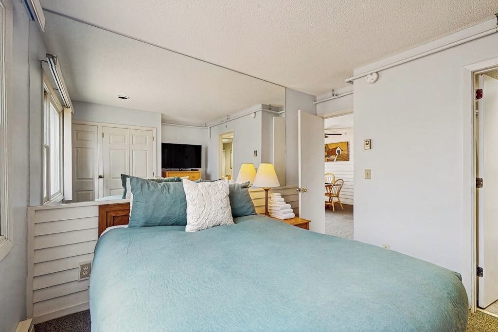 Une chambre à coucher avec un lit, une télévision, une lampe et une chaise.