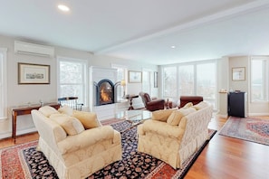 A spacious living room with a fireplace, two sofas, a coffee table, and a rug.