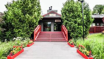 A building with a red staircase leading to a door marked 'Sunrise Cafe.'