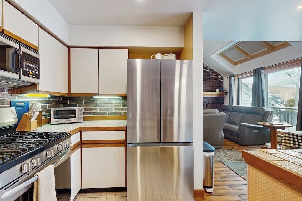 A modern kitchen with stainless steel appliances, a gas stove, and a large refrigerator.