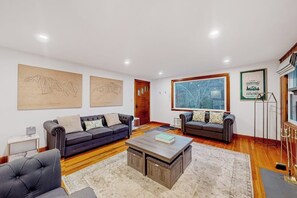 Ein modernes Wohnzimmer mit zwei Sofas, einem Couchtisch und Kunstwerken an den Wänden.