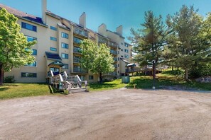 A multi-story hotel with outdoor stairs, a covered area, and a dirt parking lot. - Mountain view condo with full kitchen and free WiFi (Killington)