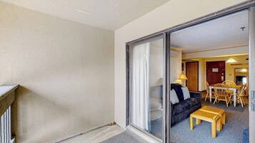 A room with a sliding glass door leading to a dining area with a table and chairs.