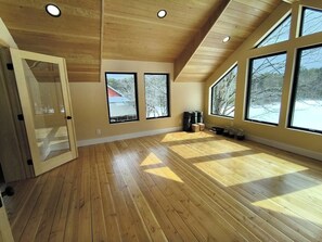 A spacious room with wooden floors, large windows, and a sloped ceiling. - Pastoral, dog-friendly home surrounded by lush woodland with free WiFi & firepit (Castleton)