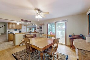 A spacious kitchen with a dining area, wooden cabinets, a ceiling fan, and a view through the glass door. - Cozy home with lake front property, views, bbq, dock, kayak, wifi, TV, w/d (Castleton)