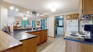 Une cuisine avec des meubles en bois, un îlot central et une cuisinière.