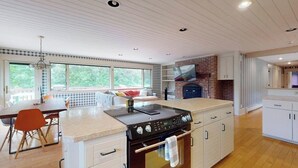 Een moderne keuken met een groot eiland, een ingebouwde oven en veel werkruimte.