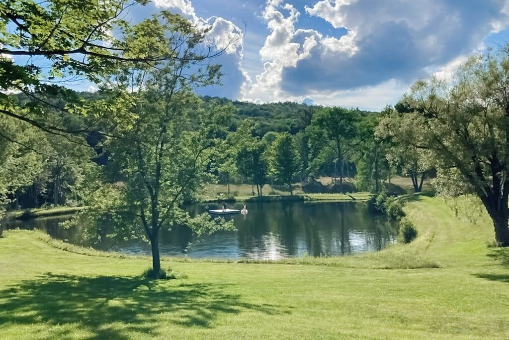 Ein ruhiger See, umgeben von üppiger Vegetation und Bäumen.