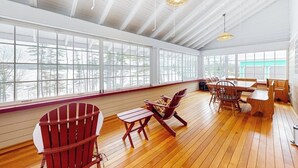 A spacious room with large windows, wooden flooring, and a high ceiling. - Lakefront house with mountain-range views, waterfront dock, 2 SUPs & kayak (Castleton)