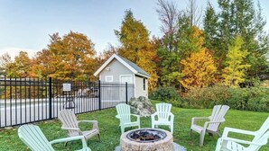 Une petite cabane avec un foyer et des sièges à l’extérieur.