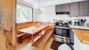 Eine Küche mit Holzbänken, einem Gaskochfeld, einem Backofen und einer Kaffeemaschine.