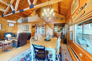 Ein Interieur einer Holzhütte mit Essbereich, einer Couch und einer Küche.