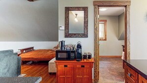 A compact living space with a bed, a small kitchenette with a microwave, a coffee maker, and a cabinet. - Spacious studio, dog-friendly, close to recreation, central a/c, TV, wifi (Barnard)