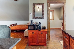 A compact living space with a bed, a small kitchenette with a microwave, a coffee maker, and a cabinet. - Spacious studio, dog-friendly, close to recreation, central a/c, TV, wifi (Barnard)