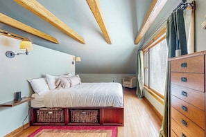 A bedroom with a bed, bedside lamps, a dresser, and a window with curtains. - Spacious studio, dog-friendly, close to recreation, central a/c, TV, wifi (Barnard)