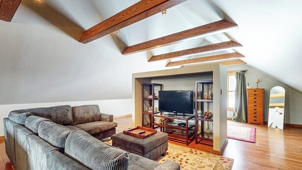 A loft-style living room with a sectional sofa, a flat-screen TV, wooden beams, and a wooden cabinet. - Spacious studio, dog-friendly, close to recreation, central a/c, TV, wifi (Barnard)