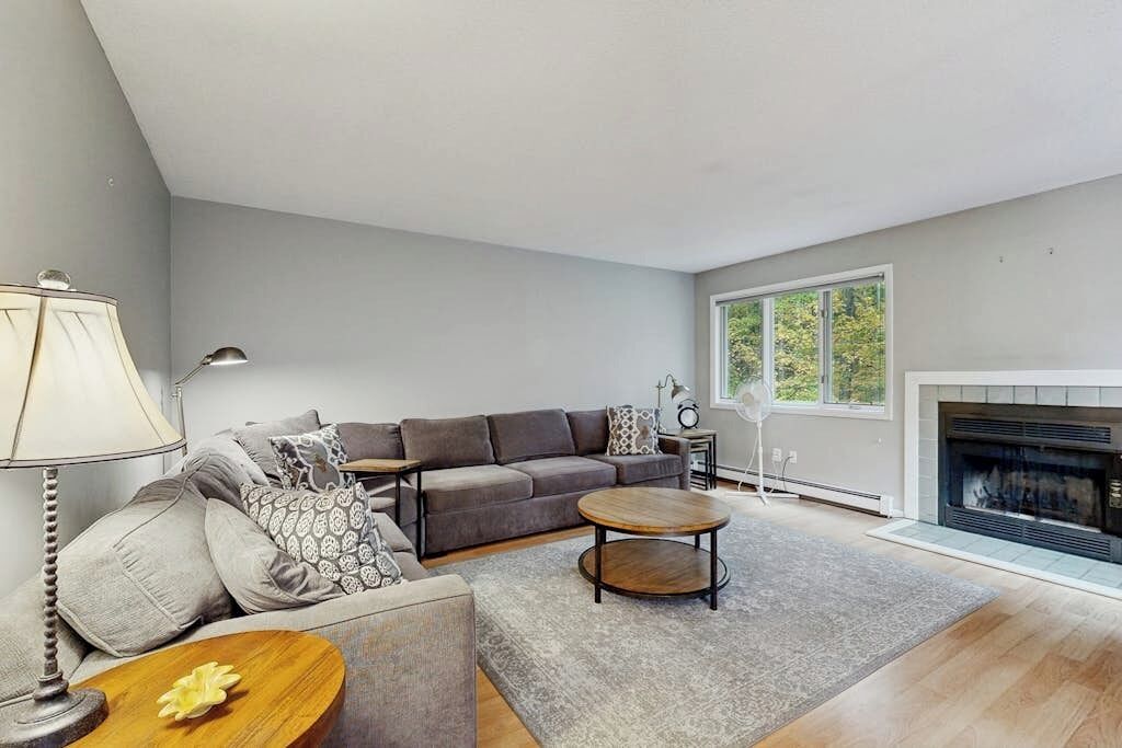 A modern living room with a sofa, coffee table, and fireplace.