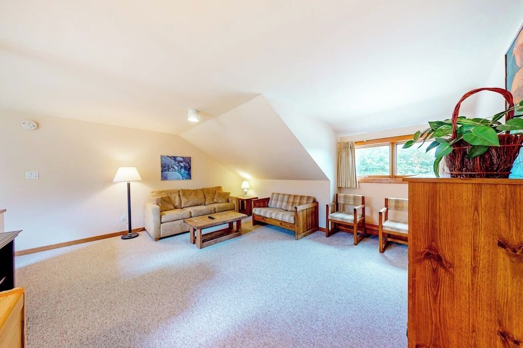 A cozy living room with a sofa, coffee table, and a wooden cabinet.