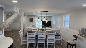 Una cocina moderna con comedor, una escalera y un televisor.