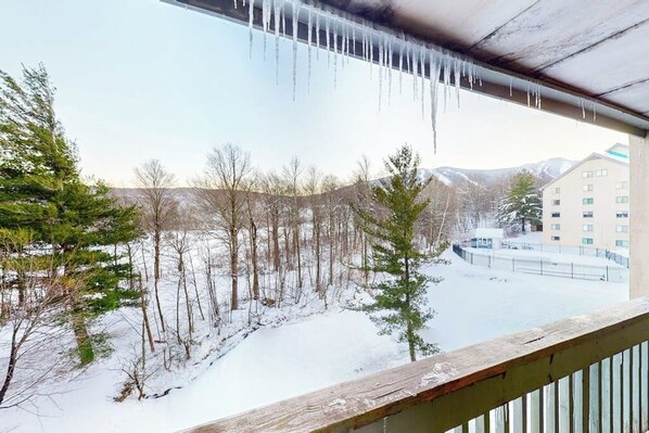 A snowy outdoor view from a balcony with icicles hanging from the ceiling. - High-floor resort condo with free WiFi and full kitchen - walk to lifts (Killington)