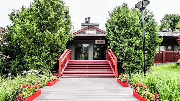 A building with a sign reading 'Sunrise Cafe' and a staircase leading to the entrance. - Ski-in/out condo with  pool, hot tub, sauna & fast WiFi (Killington)