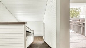 A narrow staircase with white walls and a wooden deck outside. - Ski-in/out condo with  pool, hot tub, sauna & fast WiFi (Killington)
