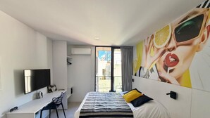 A modern hotel room with a bed, a desk, a TV, and a large window. - CloudBA Fitz Roy Apartments (Buenos Aires)