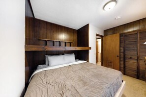 Ein Schlafzimmer mit einem Bett, einem Holz-Kopfteil und einem Kleiderschrank.