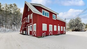 A red building with a staircase, windows, and a door. - Comfortable condo w/ mountain & ski views, central a/c, shared patio & BBQ (Waitsfield)