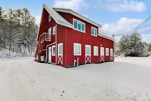 A red building with a staircase, windows, and a door. - Comfortable condo w/ mountain & ski views, central a/c, shared patio & BBQ (Waitsfield)