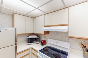 Una cocina compacta equipada con microondas, tostadora y cocina eléctrica.