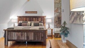 Una camera da letto con un letto in legno, due lampade sui comodini, un muro in pietra e una piccola decorazione a forma di albero.