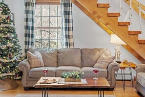 Ein gemütliches Wohnzimmer mit einer Couch, einem Couchtisch und einem Weihnachtsbaum.