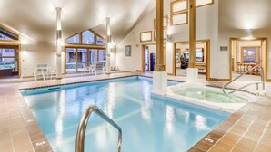 An indoor swimming pool with clear water, a hot tub, and a sunlit room with a view. - Trail Creek 33 | Condo in Killington (Killington)