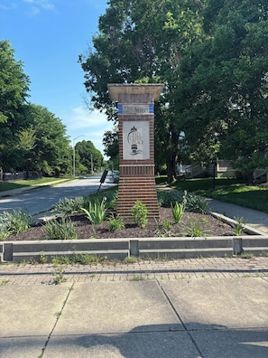 Ein Straßenschild für die '22nd Street' und 'Fall Creek Place', mit einer Ziegelbasis und einem Logo.