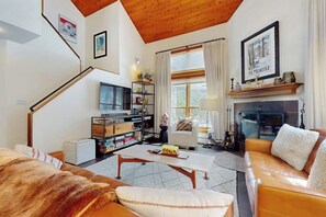 Ein gemütliches Wohnzimmer mit Kamin, Treppe und Bücherregal.