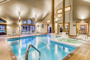 An indoor swimming pool with a jacuzzi, tiled flooring, and a view of the outside. - Trail Creek 75 | Condo in Killington (Killington)