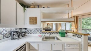 A compact kitchen with a sink, coffee maker, and a window with curtains. - Resort condo with 3 pools, sports courts, & convenient ski access (Warren)
