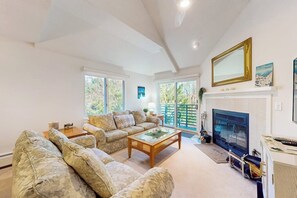 Ein Wohnzimmer mit Kamin, einer Sofagarnitur, einem Couchtisch und einem Fernseher.