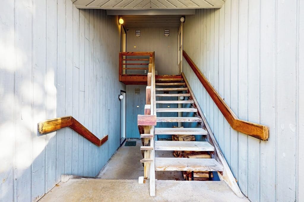 A wooden staircase with a handrail and a wooden handrail on the side.