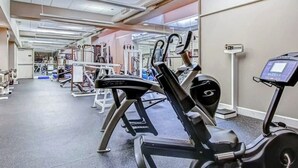 Ein Fitnessraum mit Trainingsgeräten, Laufband und Gewichtsheberbank.