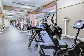 Ein Fitnessraum mit Trainingsgeräten, Laufband und Gewichtsheberbank.