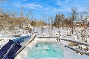 A hot tub surrounded by snow-covered landscape and trees. - Cozy, updated riverfront home with gas stove & AC (Warren)