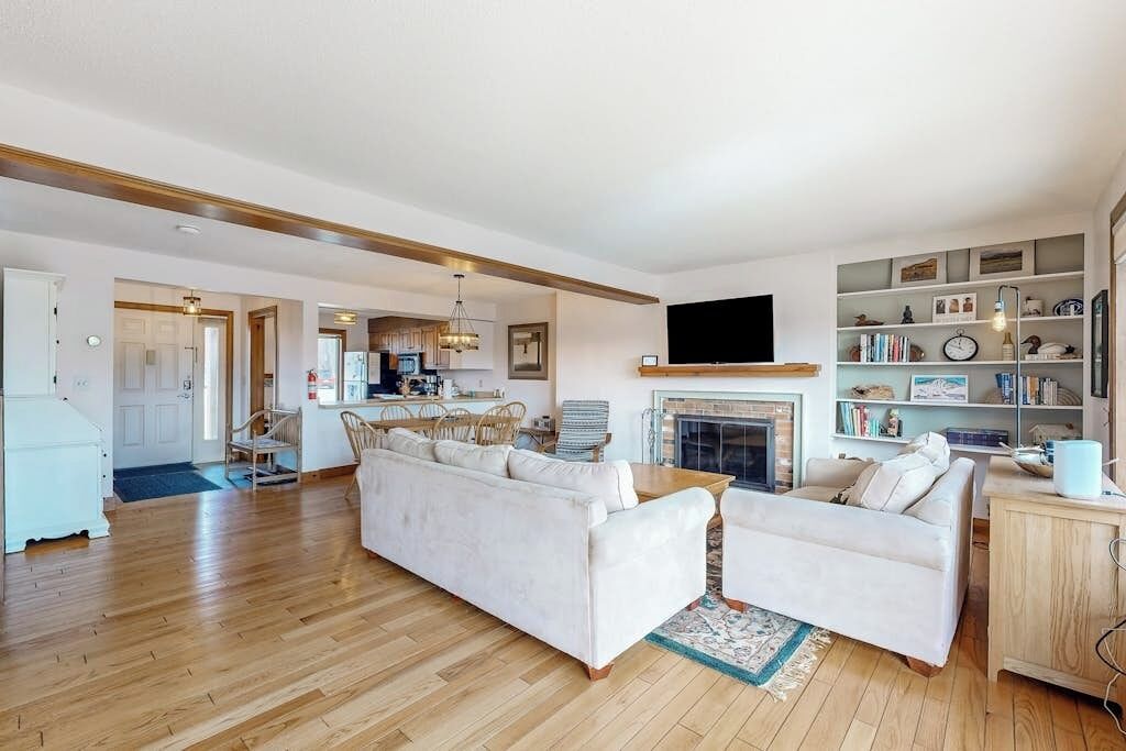 A living room with a sofa, a television, a fireplace, and a bookshelf.