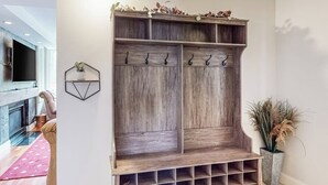 Ein hölzerner Garderobenhaken mit Haken, Ablagefläche und einem Unterteil mit Regalen.