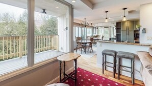 Ein geräumiger Wohnbereich mit Balkon, einer Küche und einem Essbereich.