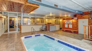 Ein Poolbereich mit einem Schild für 'Fiddlehead Tub-Club', einem Holzinnenraum und einer Glastür, die nach draußen führt.