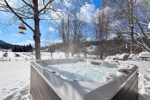 A hot tub in a snowy outdoor setting with trees and a clear sky. - Countryside home near skiing with amazing views,  firepit & hot tub (Roxbury)